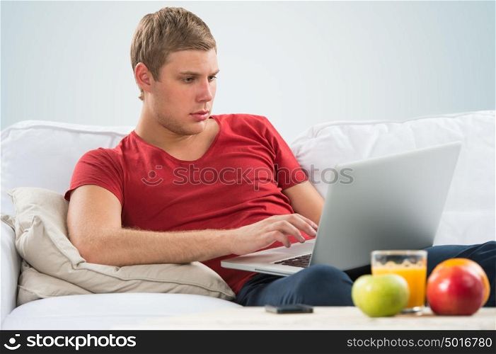 Portrait of a young guy using laptop at home