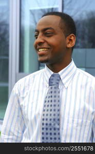 Portrait of a young handsome businessman next to a corporate building