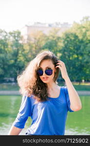 Portrait of a young handsome girl in sunglasses with dark hair. Close up sunny portrait