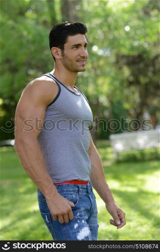 Portrait of a young handsome man, model of fashion, in the park