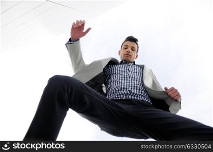 Portrait of a young handsome man, model of fashion, jumping and wearing jacket and shirt