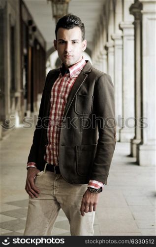 Portrait of a young handsome man, model of fashion, wearing jacket and shirt in urban background
