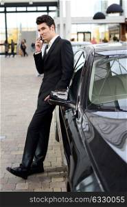 Portrait of a young handsome man, model of fashion, wearing suit and with luxury car