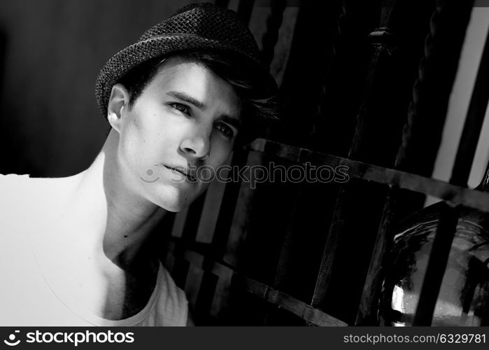 Portrait of a young handsome man, model of fashion, with modern hairstyle in urban background