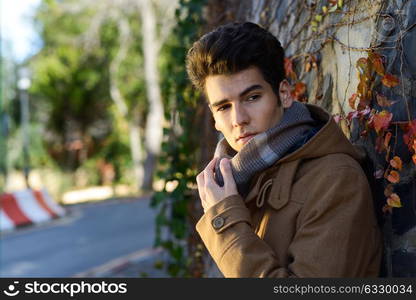 Portrait of a young handsome man, model of fashion, with toupee in a park