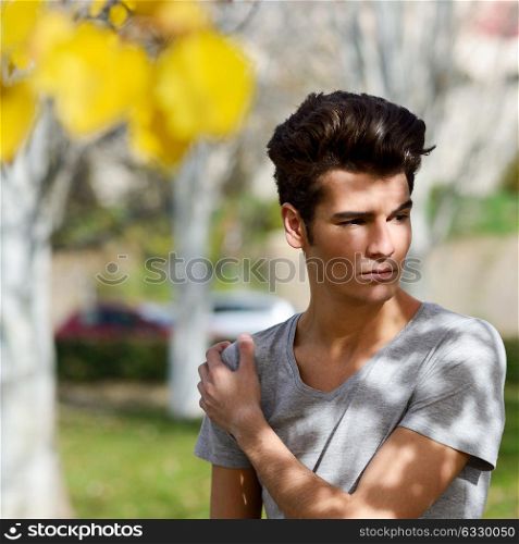 Portrait of a young handsome man, model of fashion, with toupee in the park