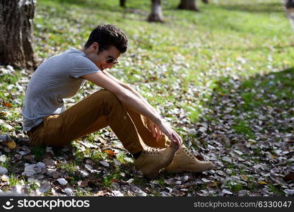 Portrait of a young handsome man, model of fashion, with toupee laughing in the park