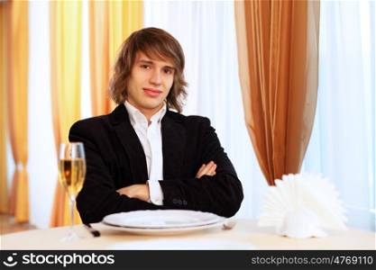 Portrait of a young handsome man sitting in restaurant