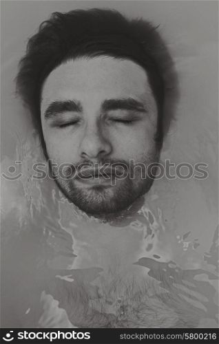 Portrait of a young handsome man taking a bath