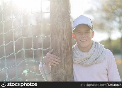 Portrait of a young handsome smiling man wearing a cap outdoors