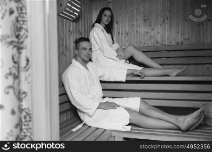 Portrait of a young happy beautiful couple enjoys relaxing in the sauna