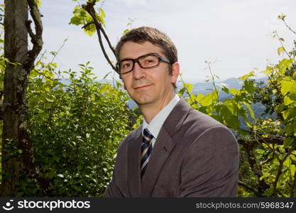 portrait of a young happy businessman with glasses, outdoors