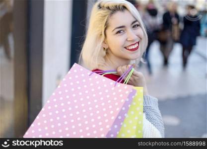 Portrait of a young happy smiling woman with shopping bags