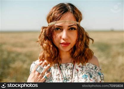 portrait of a young hippie girl on a wheat field