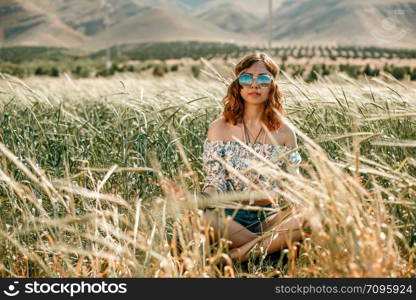 portrait of a young hippie girl on a wheat field