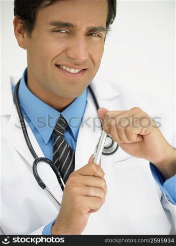 Portrait of a young male doctor holding a pen