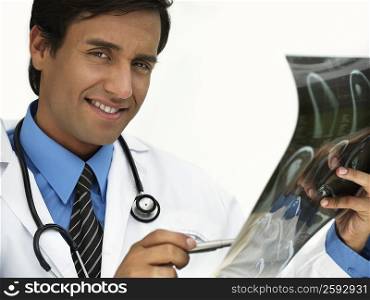 Portrait of a young male doctor holding an X-Ray and smiling