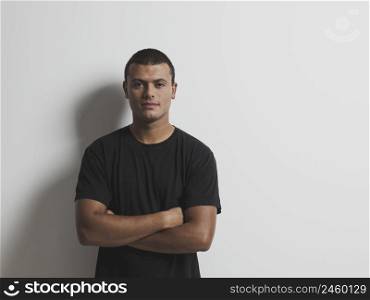 Portrait of a young male latino model against a white wall