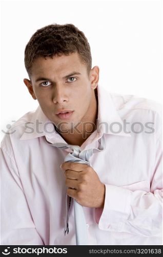 Portrait of a young man adjusting his tie