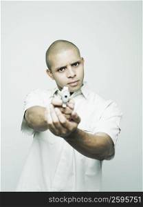 Portrait of a young man aiming a handgun