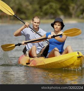 Portrait of a young man and a teenage girl kayaking