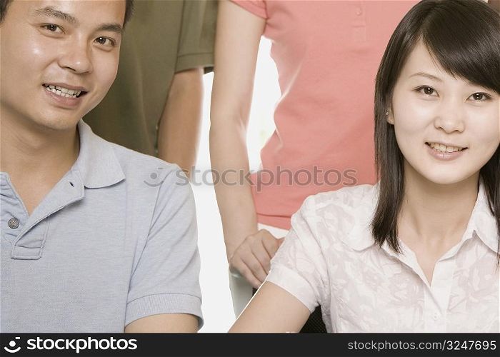 Portrait of a young man and a young woman sitting together and smiling