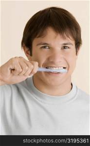 Portrait of a young man brushing his teeth
