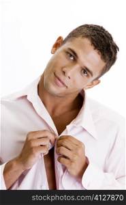 Portrait of a young man buttoning his shirt