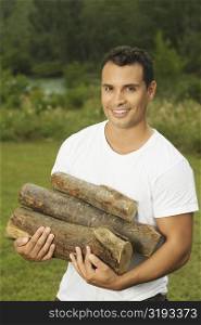 Portrait of a young man carrying firewood
