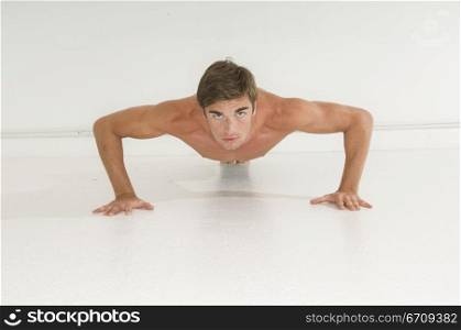 Portrait of a young man doing push-ups