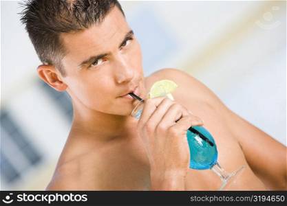 Portrait of a young man drinking a cocktail