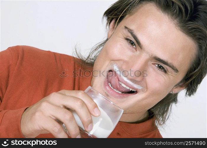 Portrait of a young man drinking milk and smiling