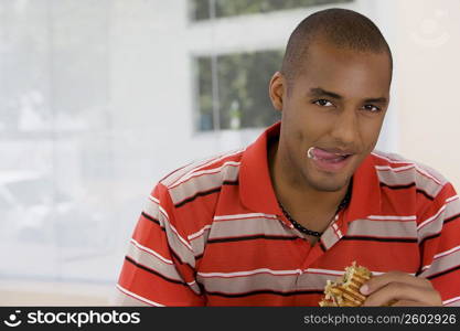 Portrait of a young man eating a sandwich