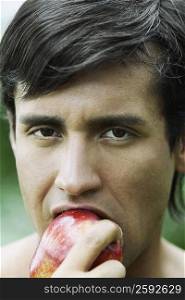 Portrait of a young man eating an apple