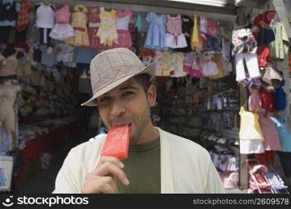 Portrait of a young man eating an ice cream