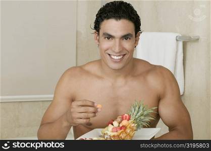 Portrait of a young man eating fruit