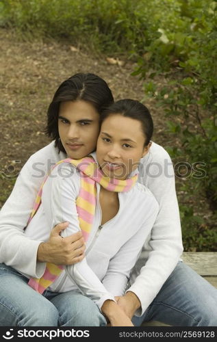 Portrait of a young man embracing a young woman from behind