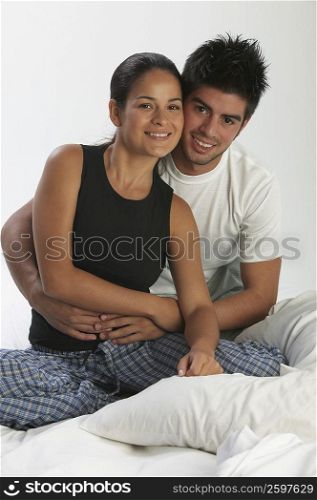 Portrait of a young man embracing a young woman from behind