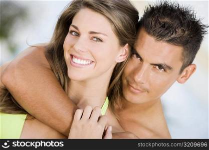 Portrait of a young man embracing a young woman from behind