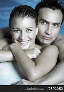 Portrait of a young man embracing a young woman in a swimming pool