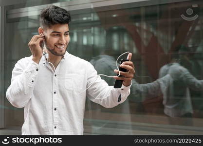 Portrait of a young man enjoying music outdoors. High quality photo. Portrait of a young man enjoying music outdoors.