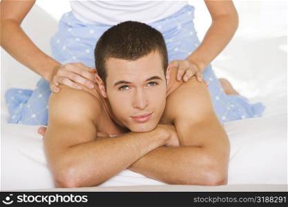Portrait of a young man getting a shoulder massage