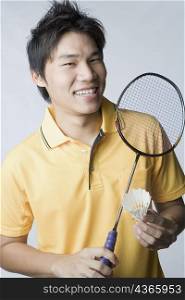 Portrait of a young man holding a badminton racket and a shuttlecock