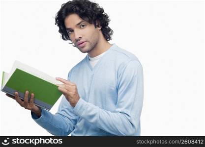 Portrait of a young man holding a book