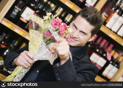 Portrait of a young man holding a bouquet of flowers