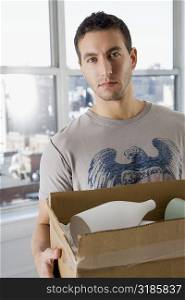 Portrait of a young man holding a cardboard box