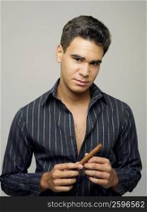 Portrait of a young man holding a cigar