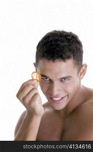 Portrait of a young man holding a condom