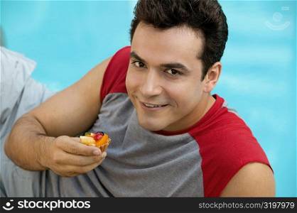 Portrait of a young man holding a cupcake