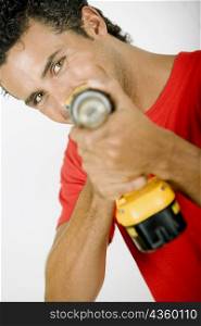 Portrait of a young man holding a drill machine